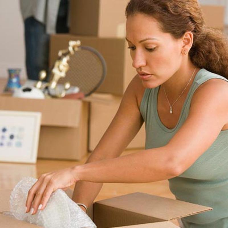 Women packing household items for a move.